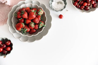 Taze yaz meyvelerini beyaz masada kaselere koyarız. Yaz yemekleri konsepti. Yumuşak odaklanma. Boşluğu kopyala