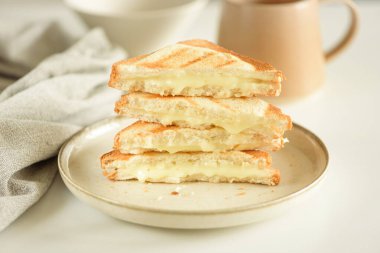 Beyaz masada erimiş peynirli sandviç yığını