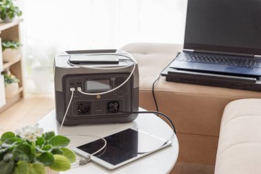 Kesintisiz güç kaynağı. Dizüstü bilgisayarı, tableti, akıllı telefonu ve taşınabilir elektrik santrali olan koltukta çalışma alanı