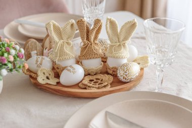 Yumurtadan yapılmış birkaç Paskalya tavşanı ve tahta tabakta örülmüş kulaklarla kutlanan Paskalya sofrası. Paskalya kutlaması kavramı