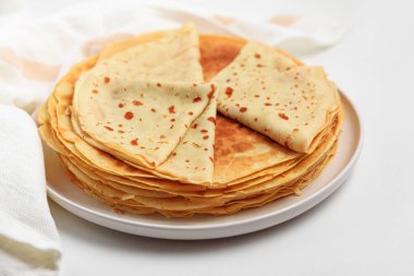 Beyaz masada bir yığın ince krep. Krep, blini. Ön görünüm