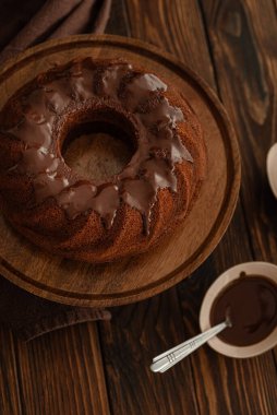 Koyu ahşap masada çikolata kremalı çikolatalı pasta. Alçakgönüllülük. Üst görünüm