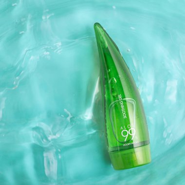 Lviv, Ukrayna - Şubat 2025: Holika Holika Aloe mavi arka planda sakinleştirici jel ile karşılaşıyor. Ürün üst görünüm çekim