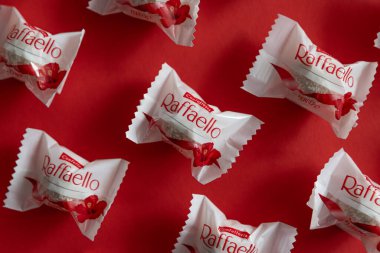 Lviv, Ukrayna - Şubat 2025: Kırmızı arka planda Raffaello çikolatalı kurabiyeler. Ürün üst görünüm çekim