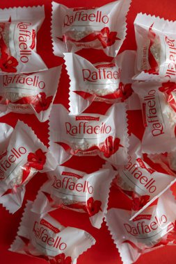 Lviv, Ukrayna - Şubat 2025: Kırmızı arka planda Raffaello çikolatalı kurabiyeler. Ürün üst görünüm çekim