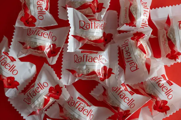 Lviv, Ukrayna - Şubat 2025: Kırmızı arka planda Raffaello çikolatalı kurabiyeler. Ürün üst görünüm çekim
