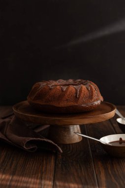 Koyu ahşap masada çikolata kremalı çikolatalı pasta. Alçakgönüllülük. Ön görünüm