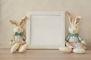 Bej arka planda Paskalya tavşanlarıyla dolu boş bir sınır. Ön görünüm