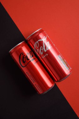 Lviv, Ukrayna - 25 Mart 2025: Demir kutular dolusu Coca Cola klasiği ve Coca Cola sıfır şeker kırmızı ve siyah zemin üzerinde. Üst görünüm