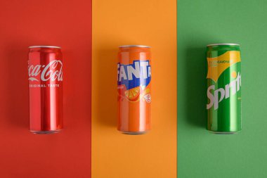 Lviv, Ukrayna - 25 Mart 2025: Renkli arka planda demir Coca Cola, Fanta ve Sprite içecekleri. Üst görünüm