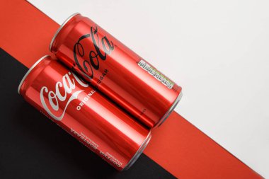 Lviv, Ukrayna - 25 Mart 2025: Demir kutular dolusu Coca Cola klasiği ve Coca Cola sıfır şekerli siyah beyaz arka plan. Üst görünüm