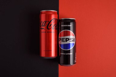 Lviv, Ukrayna - 25 Mart 2025: Kırmızı ve siyah arkaplanda demir kutu Coca Cola ve Pepsi sıfır şeker. Üst görünüm