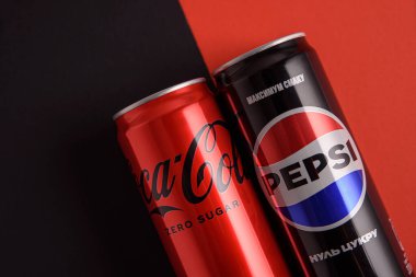 Lviv, Ukrayna - 25 Mart 2025: Kırmızı ve siyah arkaplanda demir kutu Coca Cola ve Pepsi sıfır şeker. Üst görünüm