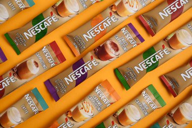 Lviv, Ukrayna - 28 Mart 2025: Nescafe Sachet hazır kahve farklı tatlar: Latte, Cappuccino, İrlanda, Choco ve Karamel sarı arka planda. Üst görünüm