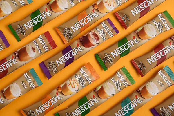 Lviv, Ukrayna - 28 Mart 2025: Nescafe Sachet hazır kahve farklı tatlar: Latte, Cappuccino, İrlanda, Choco ve Karamel sarı arka planda. Üst görünüm