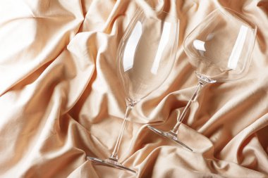 Bej rengi saten arka planda iki kadeh. Üst görünüm