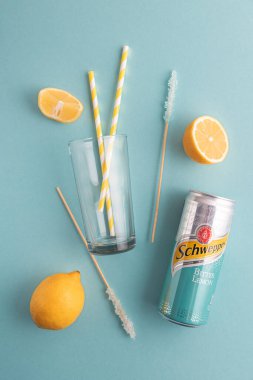 Lviv, Ukrayna - 6 Nisan 2025: Demir kutu Schweppes Bitter Lemon ve kokteyl malzemeleri. Üst görünüm