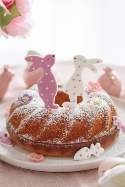 Beyaz tahta masa üzerinde tavşan şeklinde zencefilli kurabiyelerle süslenmiş geleneksel paskalya pastaları.