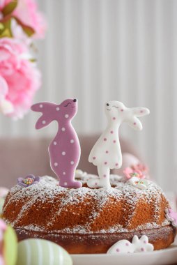 Beyaz tahta masa üzerinde tavşan şeklinde zencefilli kurabiyelerle süslenmiş geleneksel paskalya pastaları.