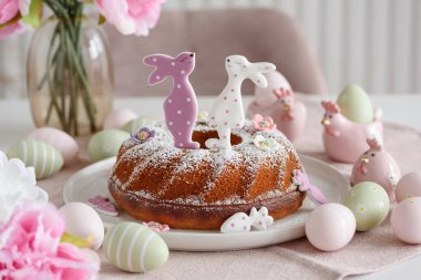 Beyaz tahta masa üzerinde tavşan şeklinde zencefilli kurabiyelerle süslenmiş geleneksel paskalya pastaları.