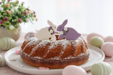 Beyaz tahta masa üzerinde tavşan şeklinde zencefilli kurabiyelerle süslenmiş geleneksel paskalya pastaları.