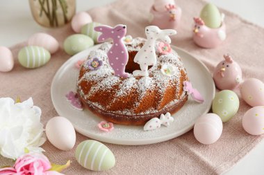 Beyaz tahta masa üzerinde tavşan şeklinde zencefilli kurabiyelerle süslenmiş geleneksel paskalya pastaları.