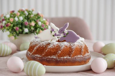 Beyaz tahta masa üzerinde tavşan şeklinde zencefilli kurabiyelerle süslenmiş geleneksel paskalya pastaları.