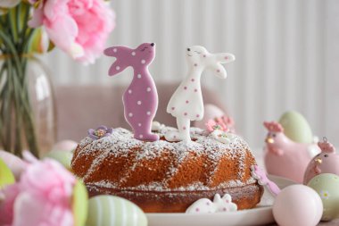 Beyaz tahta masa üzerinde tavşan şeklinde zencefilli kurabiyelerle süslenmiş geleneksel paskalya pastaları.