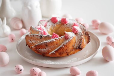 Geleneksel Paskalya pastaları, beyaz ahşap masa üzerinde süslemeli şekerler.