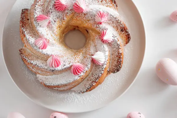 Geleneksel Paskalya pastaları, beyaz ahşap masa üzerinde süslemeli şekerler.