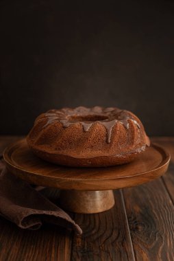 Koyu ahşap masada çikolata kremalı çikolatalı pasta. Alçakgönüllülük. Ön görünüm