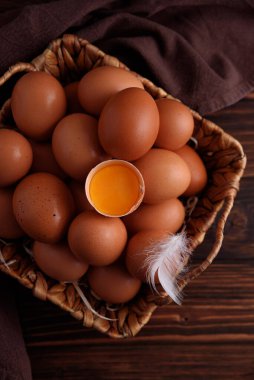 Ahşap bir arka planda kırılmış bir sepet taze çiftlik tavuğu yumurtası.