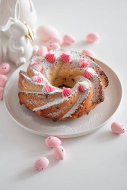 Geleneksel Paskalya pastaları, beyaz ahşap masa üzerinde süslemeli şekerler.