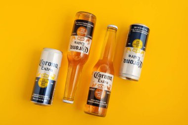 Lviv, Ukrayna - 22 Nisan 2025: Sarı arka planda Corona Extra bira şişeleri ve kutular. Üst görünüm