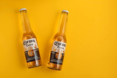 Lviv, Ukrayna - 21 Nisan 2025: Sarı zemin üzerinde iki şişe Corona Extra bira. Üst görünüm