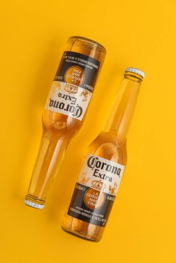 Lviv, Ukrayna - 21 Nisan 2025: Sarı zemin üzerinde iki şişe Corona Extra bira. Üst görünüm