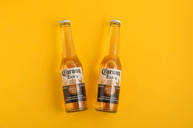 Lviv, Ukrayna - 21 Nisan 2025: Sarı zemin üzerinde iki şişe Corona Extra bira. Üst görünüm