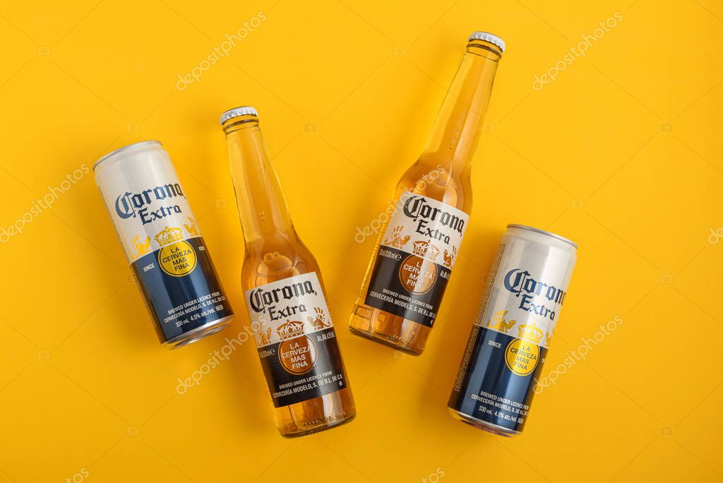 Lviv, Ukraine - April 21, 2025: Corona Extra beer bottles and cans on yellow background. Top view