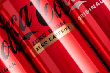 Lviv, Ukrayna - 05 Mayıs 2025: Coca Cola 'nın demir kutuları: klasik, sıfır şeker, sıfır şeker sıfır kafein, kırmızı arka planda kiraz aroması. Üst görünüm