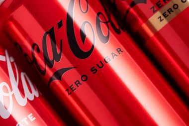 Lviv, Ukrayna - 05 Mayıs 2025: Coca Cola 'nın demir kutuları: klasik, sıfır şeker, sıfır şeker sıfır kafein, kırmızı arka planda kiraz aroması. Üst görünüm
