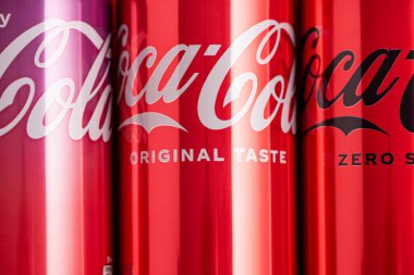 Lviv, Ukrayna - 05 Mayıs 2025: Coca Cola 'nın demir kutuları: klasik, sıfır şeker, sıfır şeker sıfır kafein, kırmızı arka planda kiraz aroması. Üst görünüm