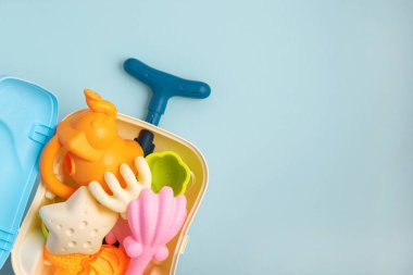 Renkli ve eğlenceli yaz çocukları mavi arka planda kalıplar ve oyuncaklar olan plaj valizleri. Üst Manzara. Boşluğu kopyala