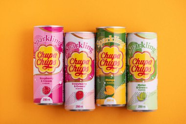 Lviv, Ukrayna - 6 Mayıs 2025: Demir içki kutuları Chupa Chups: sarı arka planda çilek, kavun, mango ve ahududu aroması. Üst görünüm