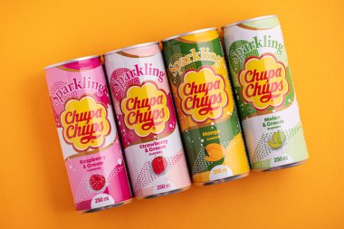 Lviv, Ukrayna - 6 Mayıs 2025: Demir içki kutuları Chupa Chups: sarı arka planda çilek, kavun, mango ve ahududu aroması. Üst görünüm