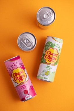 Lviv, Ukrayna - 6 Mayıs 2025: Demir içki kutuları Chupa Chups: sarı arka planda çilek, kavun, mango ve ahududu aroması. Üst görünüm