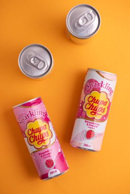 Lviv, Ukrayna - 6 Mayıs 2025: Demir içki kutuları Chupa Chups: sarı arka planda çilek, kavun, mango ve ahududu aroması. Üst görünüm