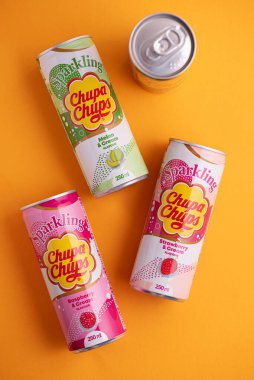 Lviv, Ukrayna - 6 Mayıs 2025: Demir içki kutuları Chupa Chups: sarı arka planda çilek, kavun, mango ve ahududu aroması. Üst görünüm