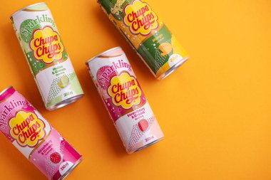 Lviv, Ukrayna - 6 Mayıs 2025: Demir içki kutuları Chupa Chups: sarı arka planda çilek, kavun, mango ve ahududu aroması. Üst görünüm