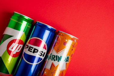 Lviv, Ukrayna - 25 Mayıs 2025: Kırmızı arka planda Pepsi Klasik Soda, 7up ve Mirinda Cans sınırı. Üst görünüm