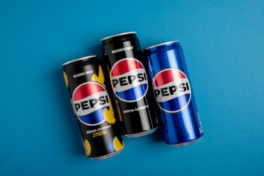 Lviv, Ukrayna - 25 Mayıs 2025: Pepsi Zero Sugar Soda, Klasik Soda ve Sıfır Şeker Citrus Soda Konserveleri mavi arka planda. Üst görünüm
